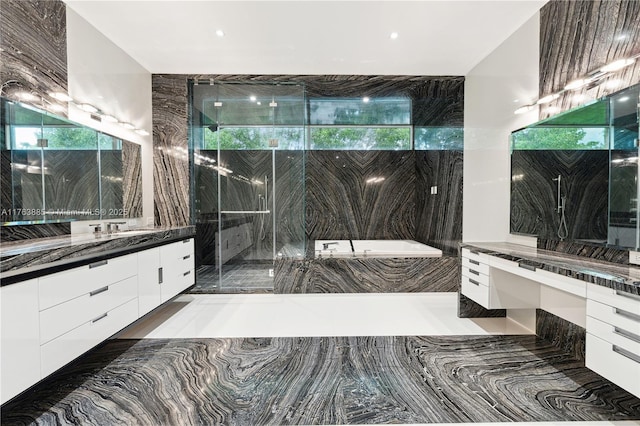 full bathroom with a tub with marble appearance and vanity