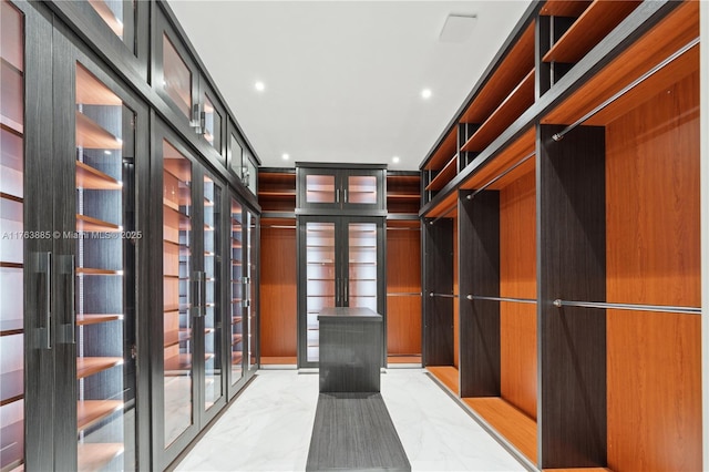 walk in closet featuring marble finish floor