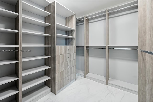 walk in closet featuring marble finish floor