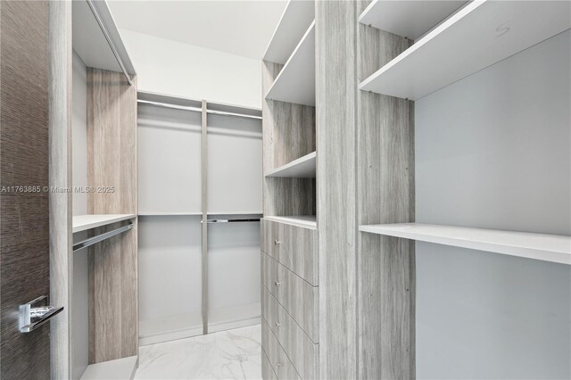 walk in closet with marble finish floor