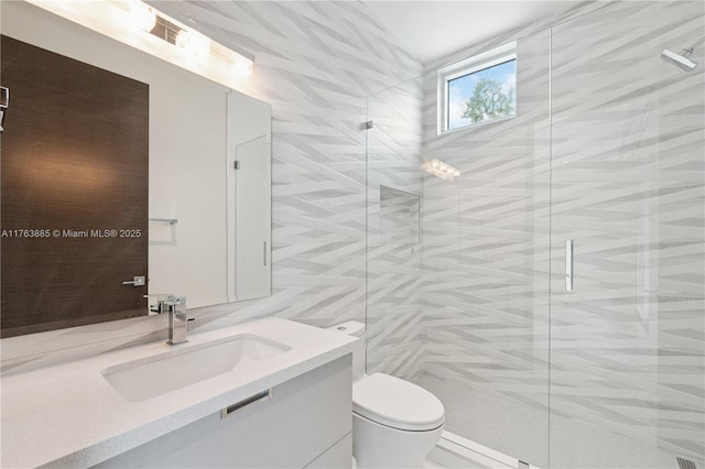 bathroom featuring tile walls, a stall shower, toilet, and vanity