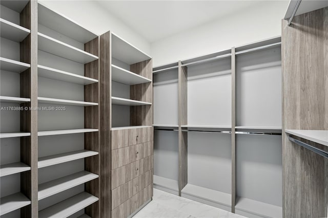 walk in closet with marble finish floor