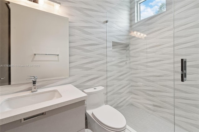 full bath featuring vanity, toilet, tile walls, and a shower stall