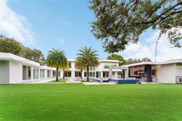 back of house with a lawn and stucco siding