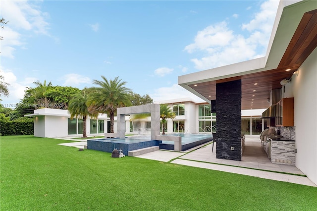 exterior space featuring a yard, area for grilling, an in ground hot tub, and stucco siding