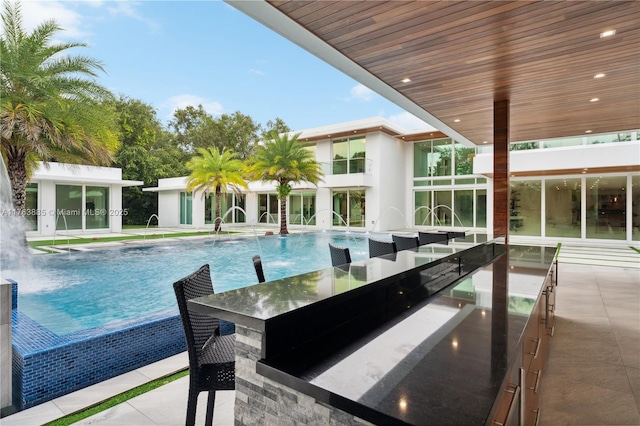 view of swimming pool with an infinity pool and a patio area