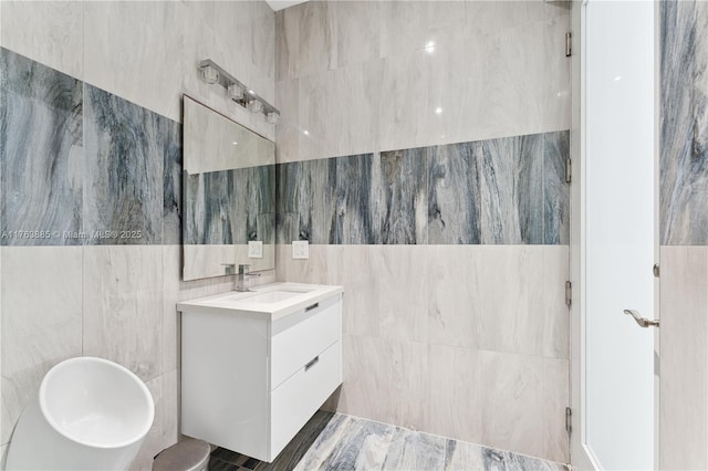 bathroom with vanity and tile walls