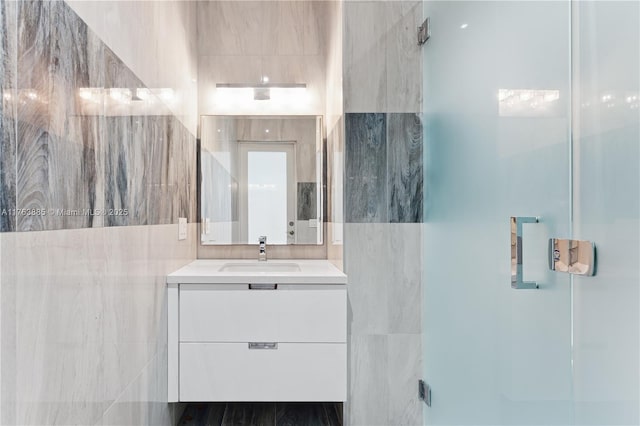 bathroom with vanity and tile walls