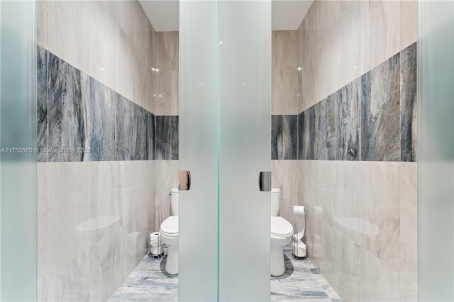 bathroom featuring tile walls, toilet, and tile patterned floors