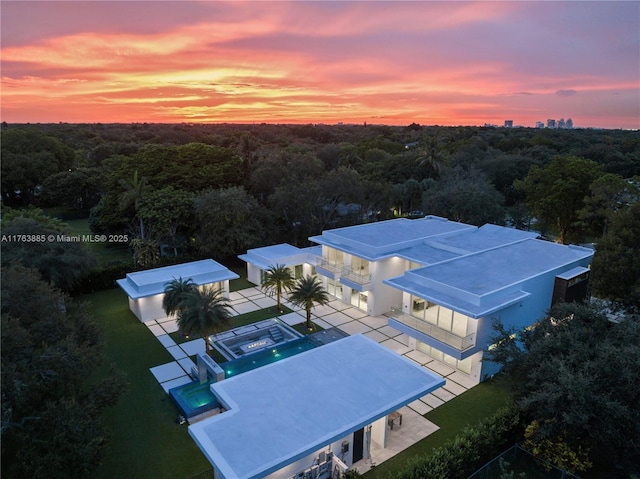 drone / aerial view featuring a wooded view