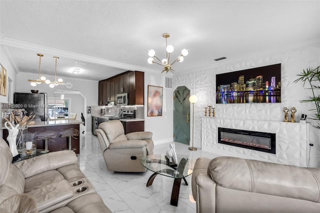 living room with visible vents, marble finish floor, a fireplace, crown molding, and a chandelier