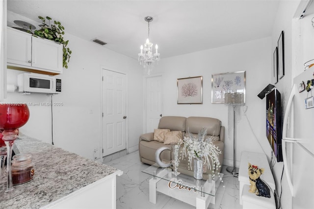 living room with visible vents, marble finish floor, and a chandelier