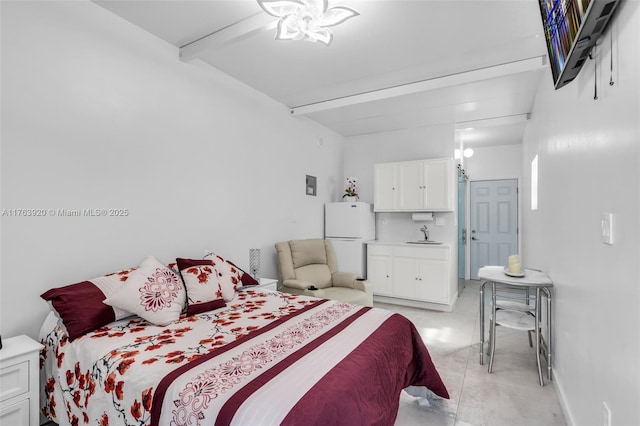 bedroom featuring beam ceiling, freestanding refrigerator, and a sink