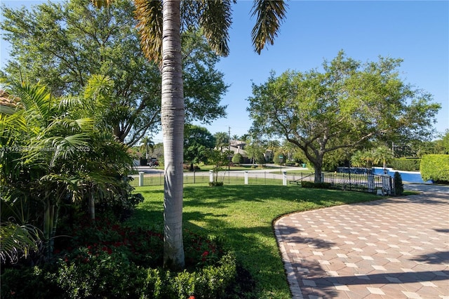 view of community featuring a yard and fence