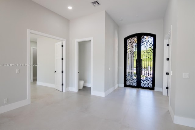 entrance foyer with visible vents, recessed lighting, french doors, arched walkways, and baseboards