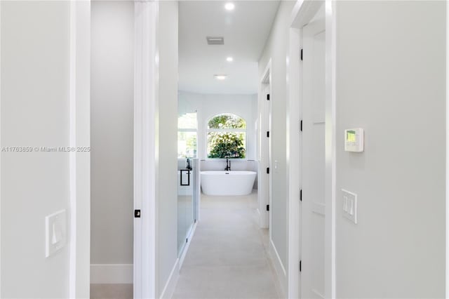 hall featuring recessed lighting and baseboards