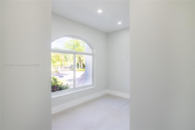 unfurnished room with recessed lighting and baseboards