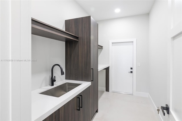 interior space featuring recessed lighting, baseboards, and a sink