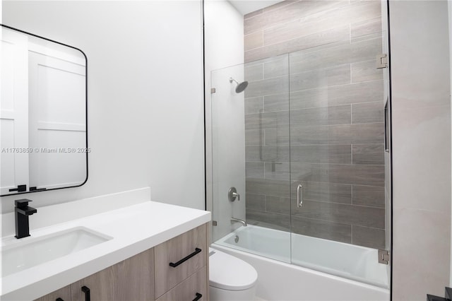 full bath with vanity, toilet, and combined bath / shower with glass door