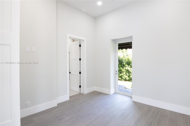 spare room with recessed lighting, wood finished floors, and baseboards