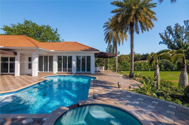 view of swimming pool featuring a patio area and a pool with connected hot tub