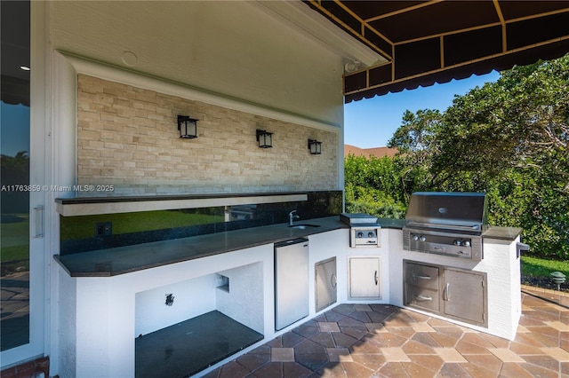 view of patio with an outdoor kitchen and a grill