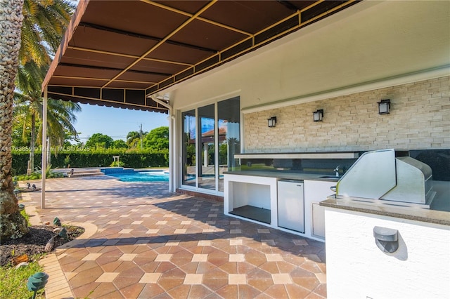 view of patio / terrace with area for grilling, a fenced in pool, and a sink