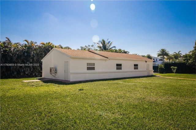 back of property featuring a yard and stucco siding