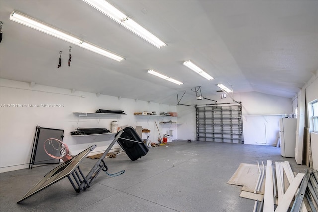 garage featuring a garage door opener and freestanding refrigerator