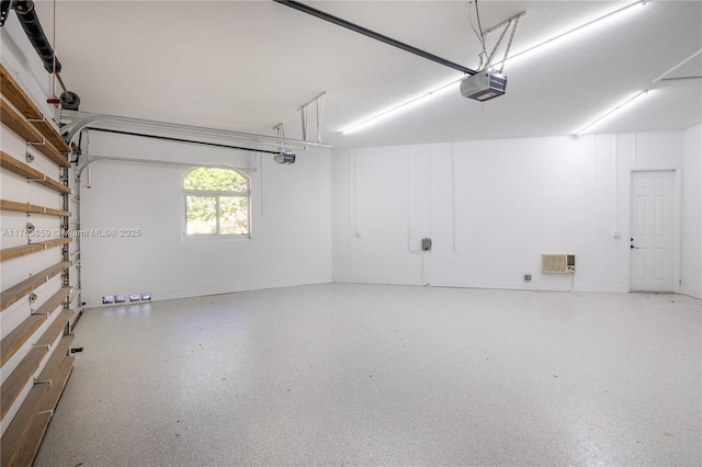 garage with an AC wall unit and a garage door opener