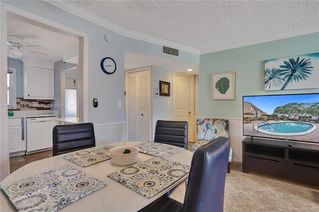 dining room featuring visible vents, a textured ceiling, ceiling fan, and ornamental molding