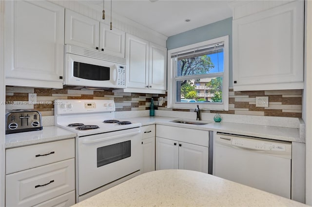 kitchen with tasteful backsplash, white appliances, white cabinetry, and a sink