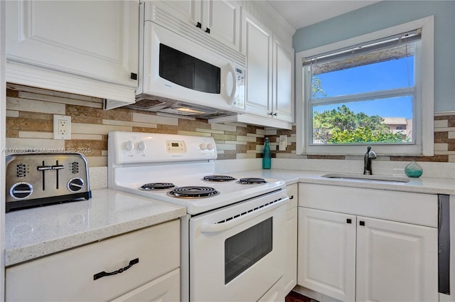 kitchen with tasteful backsplash, white appliances, white cabinetry, and a sink