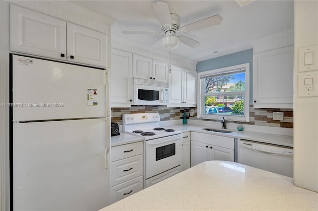 kitchen featuring decorative backsplash, white appliances, white cabinetry, and a sink