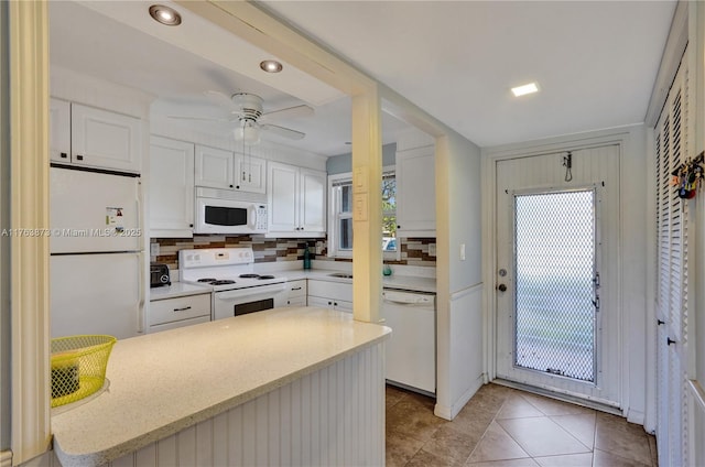 kitchen featuring white appliances, backsplash, ceiling fan, and white cabinetry