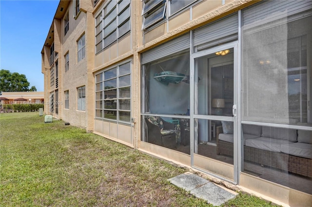 view of side of property featuring stucco siding and a lawn