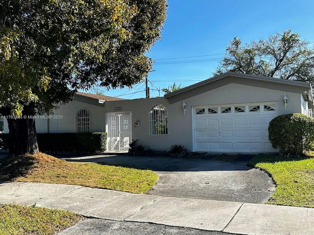 single story home with aphalt driveway, stucco siding, and an attached garage