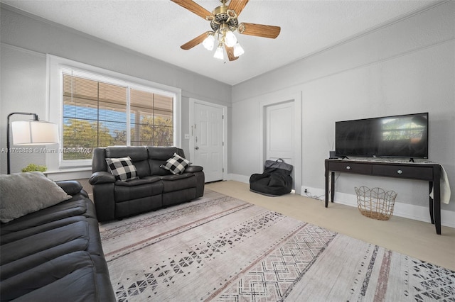 living area featuring a textured ceiling, baseboards, a ceiling fan, and carpet floors