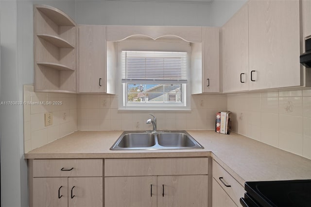 kitchen featuring open shelves, light brown cabinetry, a sink, light countertops, and backsplash