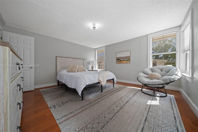 bedroom featuring dark wood finished floors, a textured ceiling, and baseboards