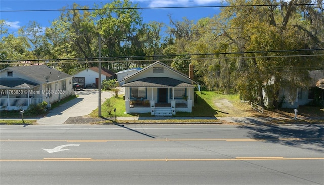 bungalow-style home featuring a front yard and covered porch