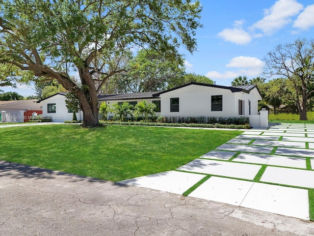 view of front of home with metal roof, a front yard, and a standing seam roof