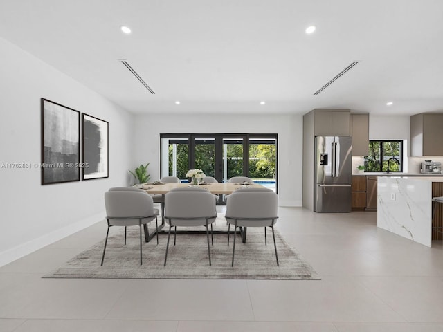 dining space with recessed lighting, a healthy amount of sunlight, and baseboards