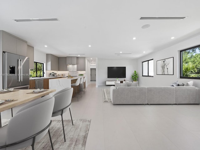 living room with light tile patterned flooring, recessed lighting, and visible vents