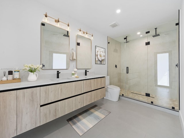 full bathroom with visible vents, toilet, double vanity, a stall shower, and a sink