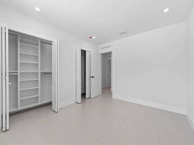 unfurnished bedroom featuring visible vents, recessed lighting, baseboards, and multiple closets