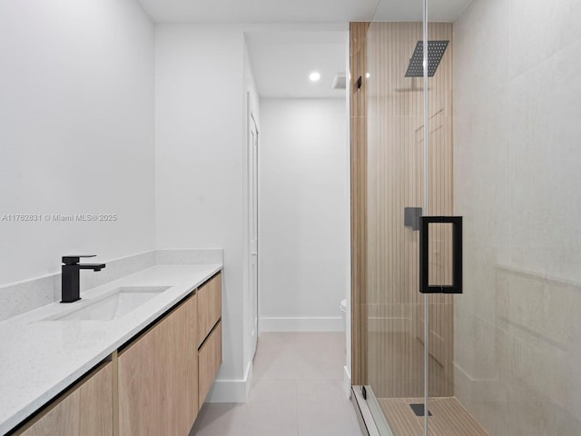 bathroom featuring toilet, a shower stall, tile patterned flooring, baseboards, and vanity