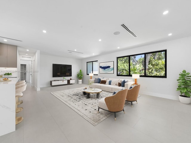 living area featuring recessed lighting, visible vents, and baseboards