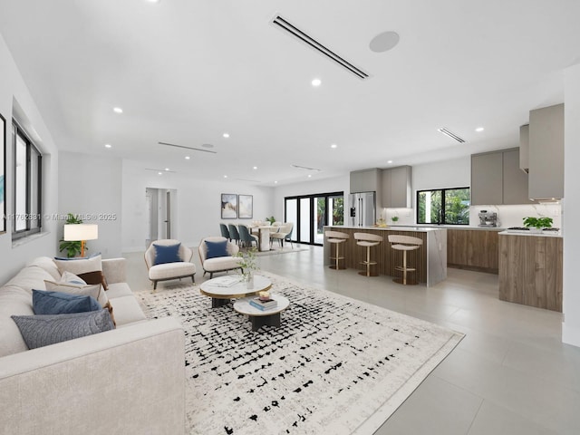 living room with light tile patterned floors, recessed lighting, and visible vents