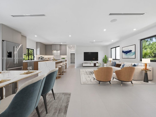 living room featuring light tile patterned flooring, visible vents, and recessed lighting